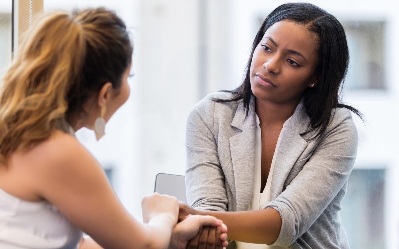 Terapeuta escuchando con empatía a paciente, acompañamiento emocional en psicooncología